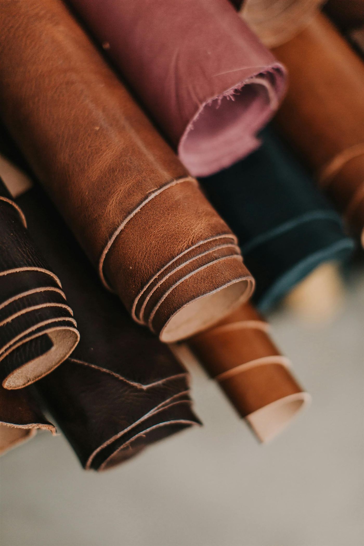 Rolled hides in brown, plum and deep green